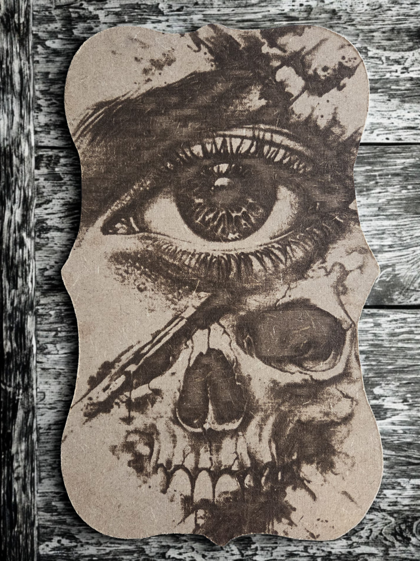 Dark horror wood art featuring a skull and eerie eye engraving.