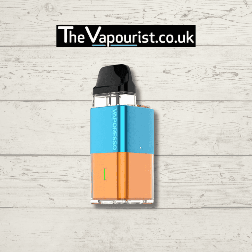 Two-tone blue and orange Vaporesso XROS Cube Pod Kit with 900mAh battery and stylish finish, shown on wood surface for TheVapourist.co.uk.